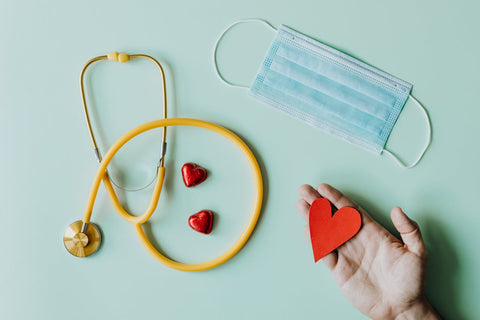 Medical stethoscope and mask composed with red foiled chocolate hearts